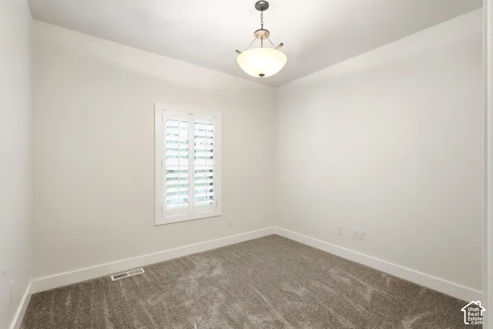 Recessed window with white plantation shutters, neutral-tone carpeting, and a semi-flush mount ceiling light fixture