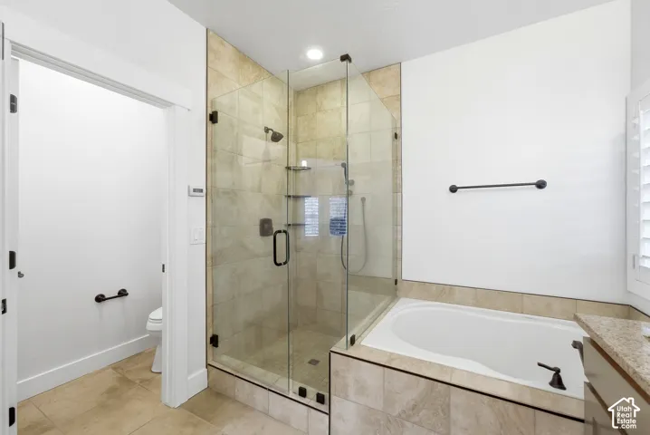 Glass-enclosed shower with tiled surround, built-in shelving, and dark bronze fixtures