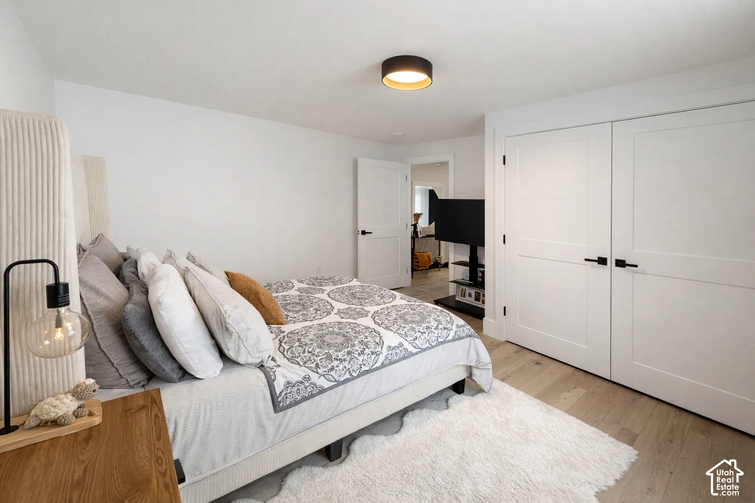 Wood-finish flooring, white walls, and a contemporary ceiling light fixture