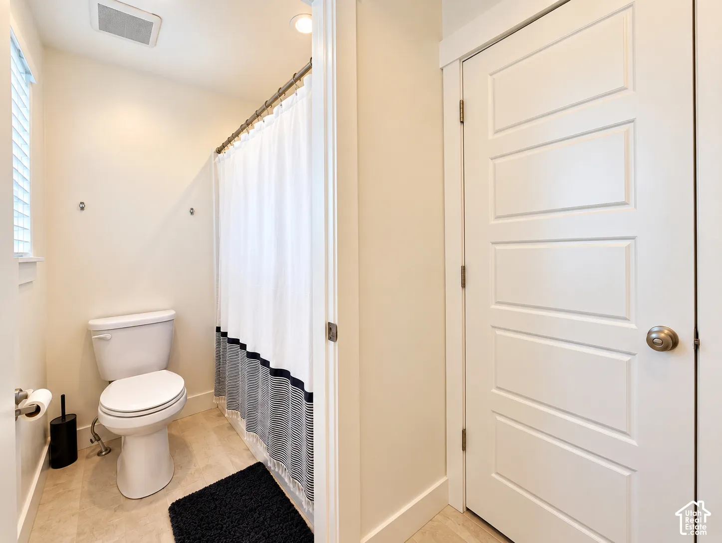 Recessed ceiling lighting, tiled flooring, window with blinds, panel door with brushed nickel hardware