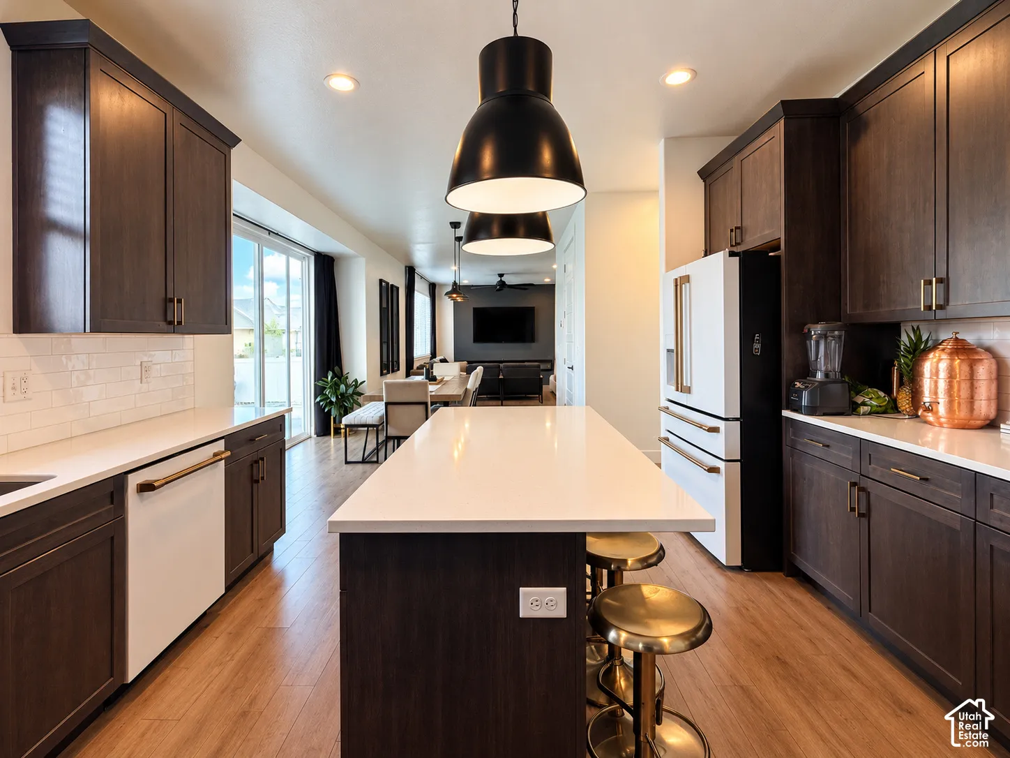 Kitchen featuring dark wood-finish cabinetry, white countertops, subway tile backsplash, and wood-finish flooring