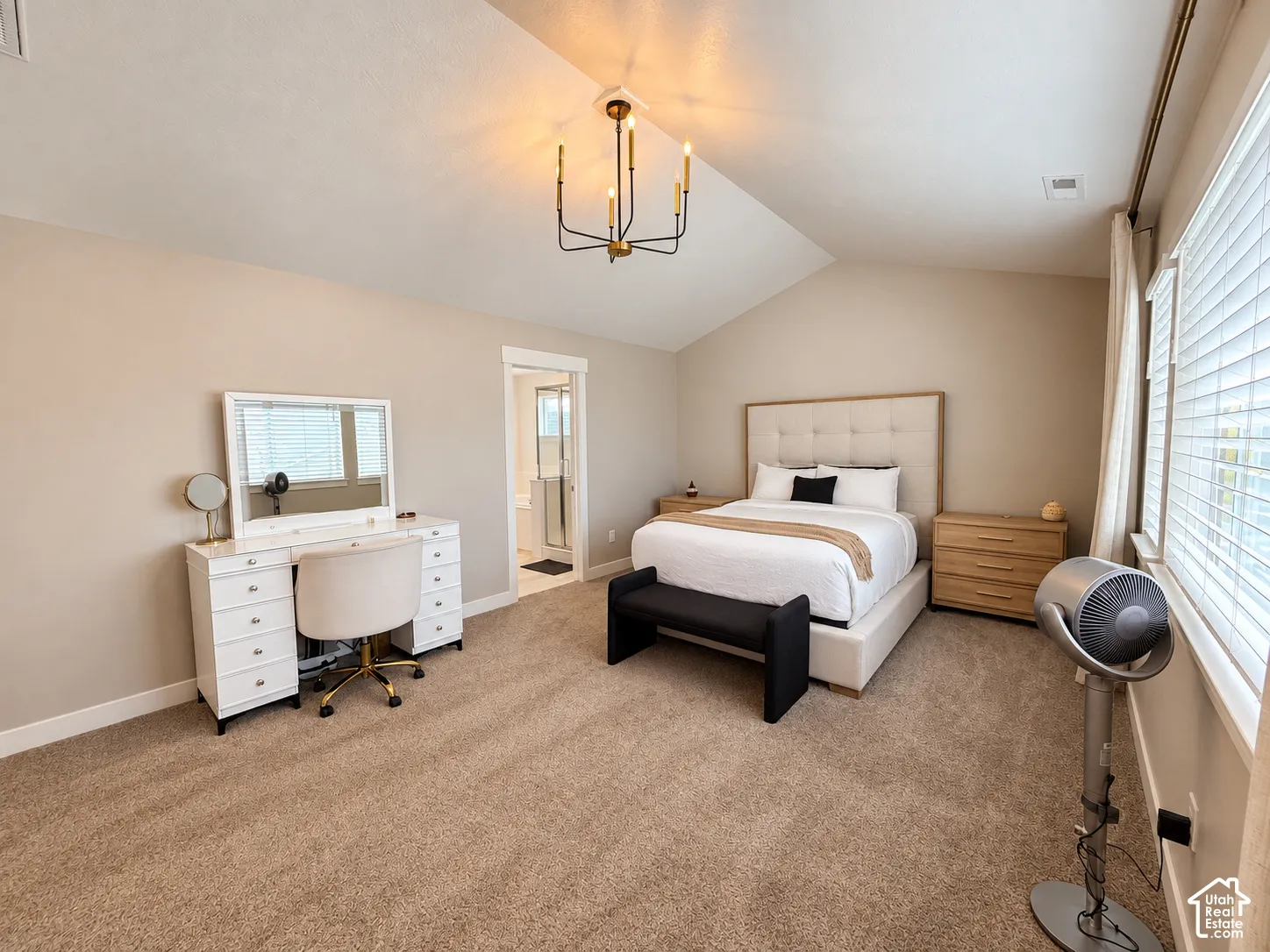 Vaulted ceiling with an attached chandelier, plush carpet, and white window blinds