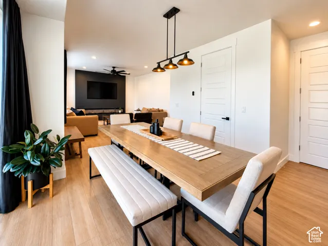 Open-concept living area with wood-finish flooring, recessed lighting, and a modern linear chandelier