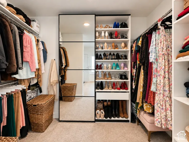Built-in closet system featuring mirrored sliding doors, extensive shelving, and multiple hanging rods