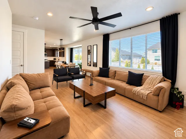 Open-concept living area with wood-finish flooring, recessed lighting, and a multi-pane window