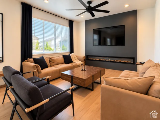 Recessed lighting, wood-finish flooring, and a ceiling fan with integrated lighting