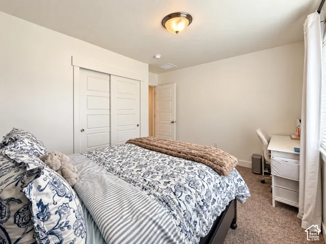 Neutral-toned walls with carpet flooring, a ceiling-mounted light fixture, and a white paneled door