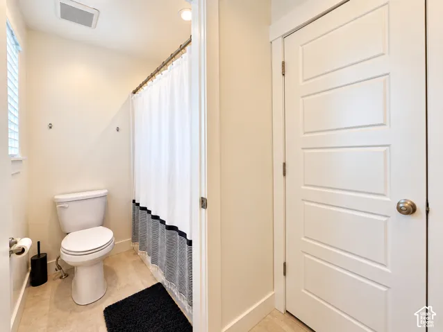 Recessed ceiling lighting, tiled flooring, window with blinds, panel door with brushed nickel hardware