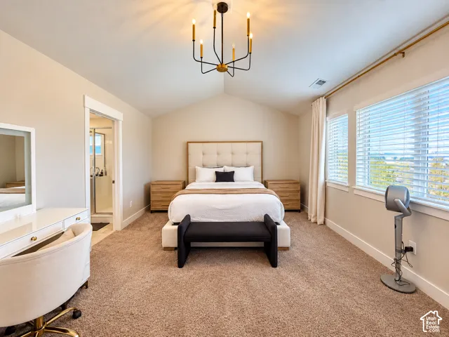 Vaulted ceiling with a chandelier, carpet flooring, multiple windows with blinds, and an attached bath with a glass-enclosed shower