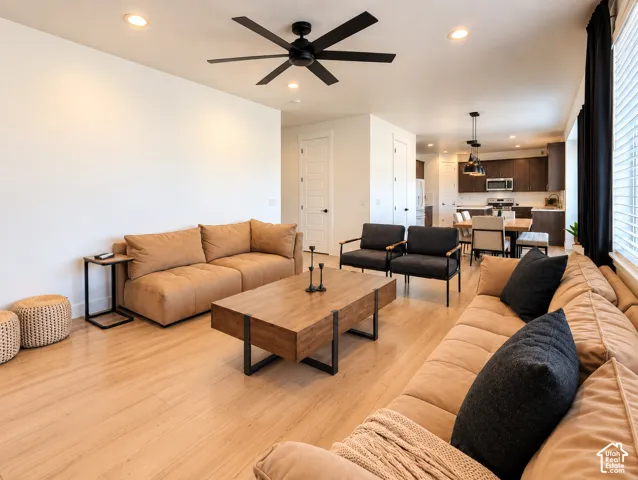 Recessed lighting, wood-finish flooring, a ceiling fan, and dark-toned window treatments