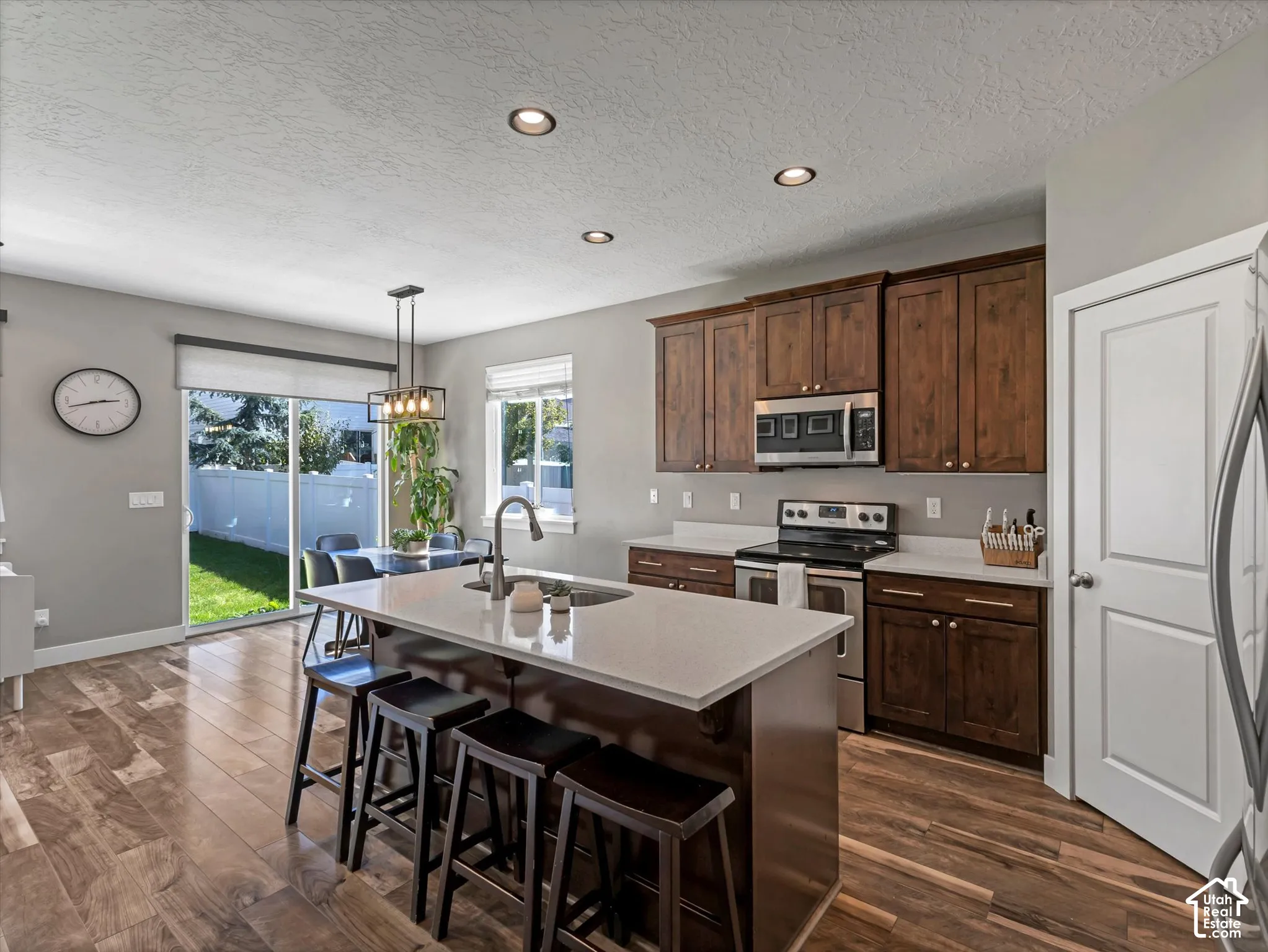 Open-concept kitchen featuring wood-finish flooring, recessed lighting, and a kitchen island with seating
