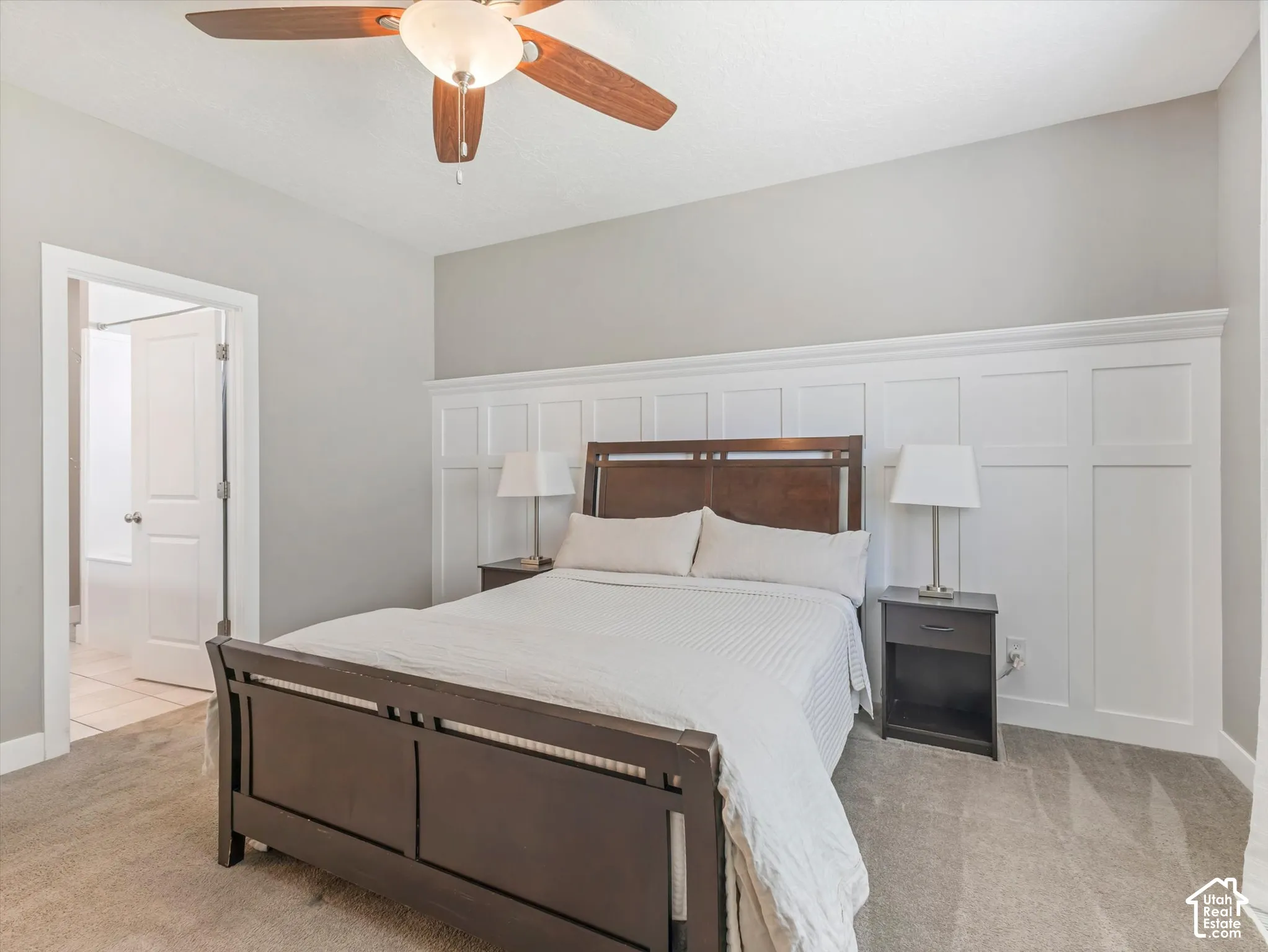 Carpeted flooring with a contrasting accent wall featuring wainscoting