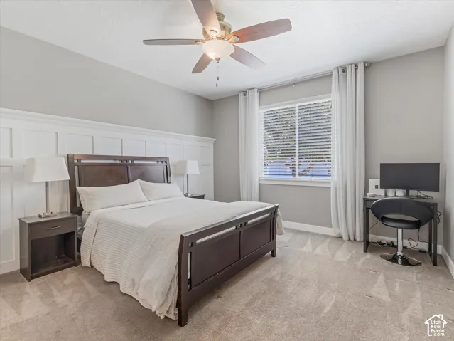 Board and batten wall accent, ceiling fan with integrated lighting, window with blinds and drapes, and neutral wall color