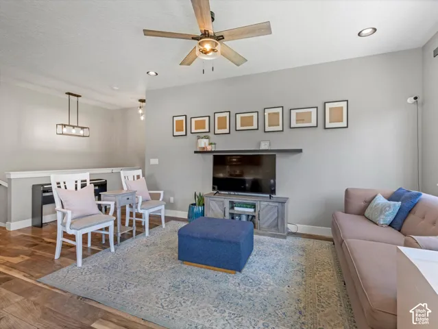 Wood-finish flooring with a ceiling fan light fixture and recessed lighting