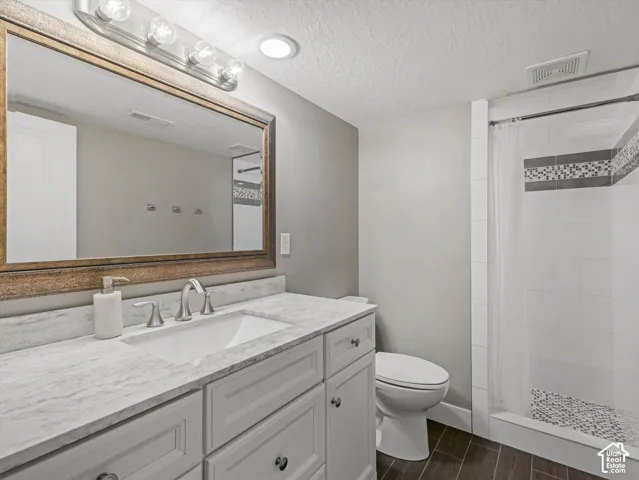 White vanity with a light-colored countertop, undermount sink, and brushed nickel faucet