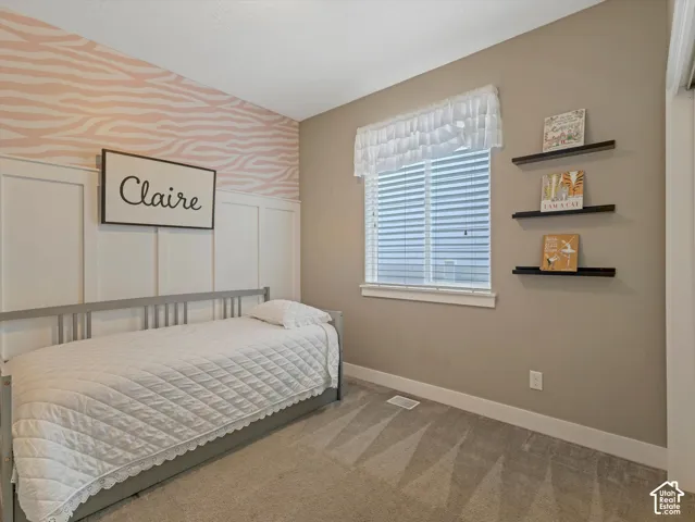 Board and batten wall detailing, patterned accent wall, window with blinds, and carpeted flooring