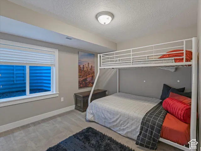 Recessed window with white blinds, neutral wall paint, white trim throughout, and plush gray carpeting