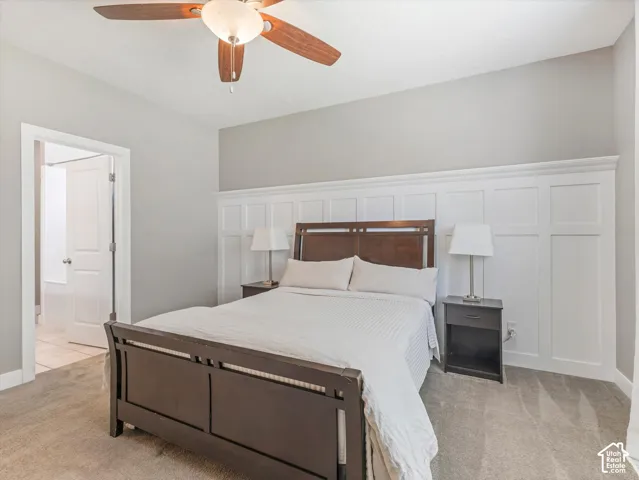 Carpeted flooring with a contrasting accent wall featuring wainscoting