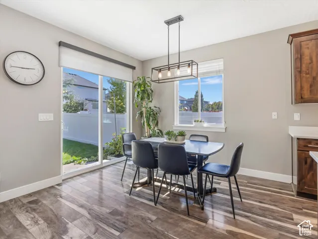 Wood-finish flooring, sliding glass door, white trim, recessed lighting, and a modern rectangular chandelier