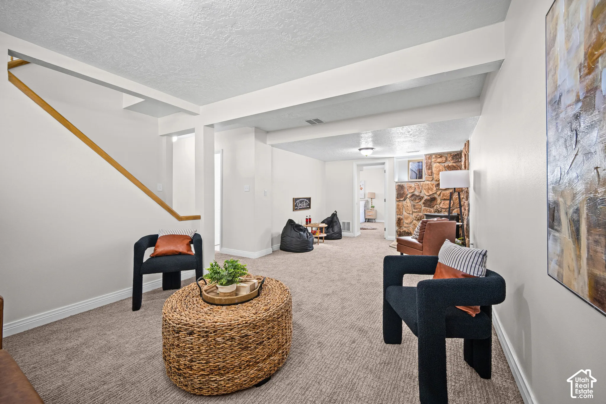 Carpeted floor, wood-finish handrail, recessed lighting, and a stone accent wall
