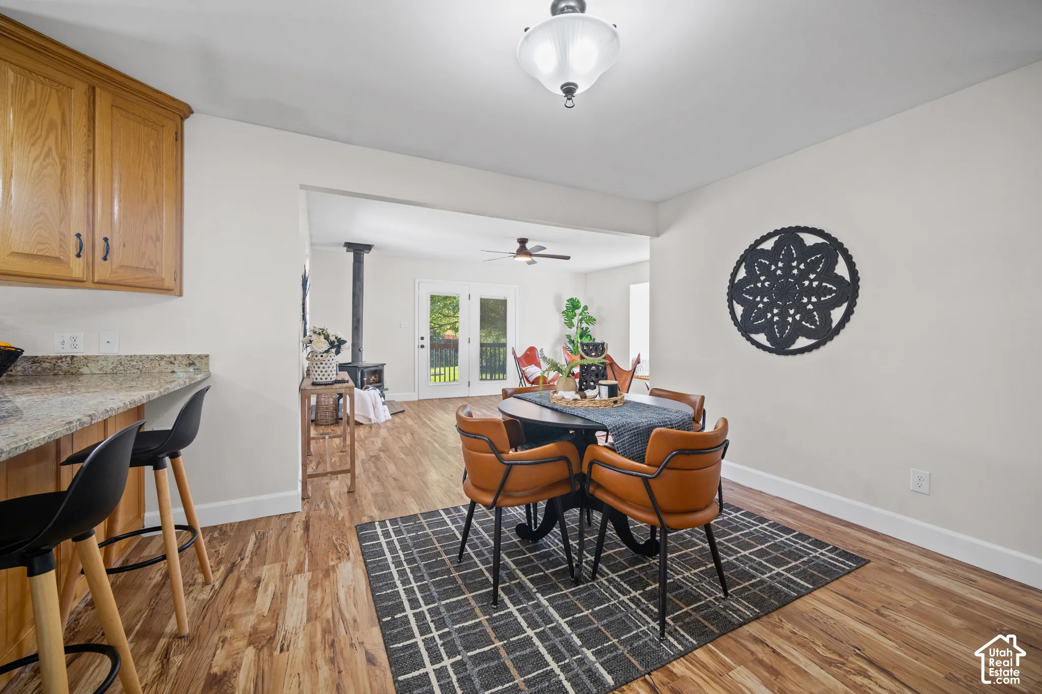 Wood-finish flooring throughout, light wood-tone cabinetry with black hardware, and an open concept layout