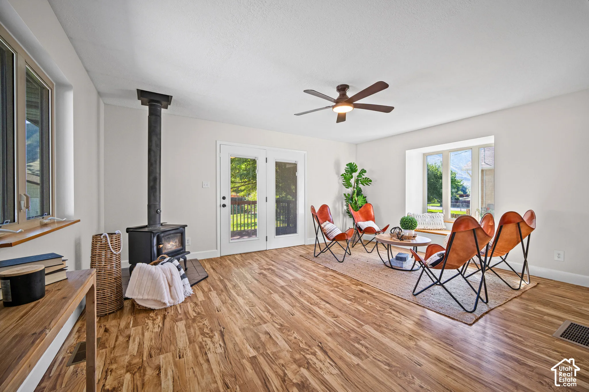 Wood-finish flooring throughout, featuring a cast-iron wood-burning stove and double glass French doors