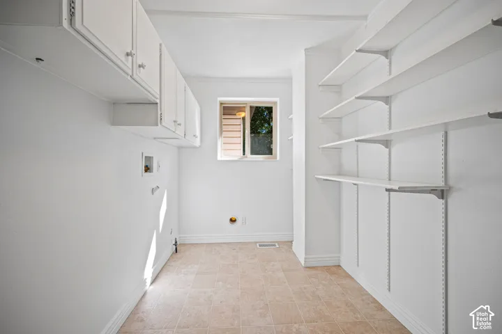 Upper cabinetry with white finish, adjustable shelving, and a window for natural light