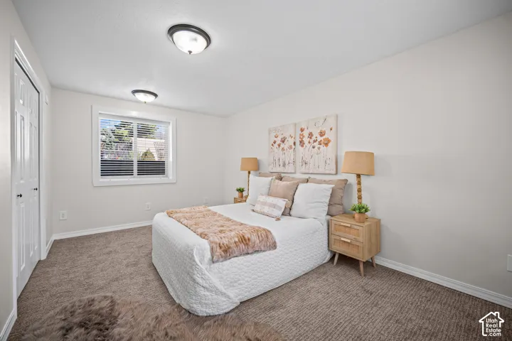 Neutral wall paint, textured carpet flooring, white trim window, and permanent ceiling light fixtures
