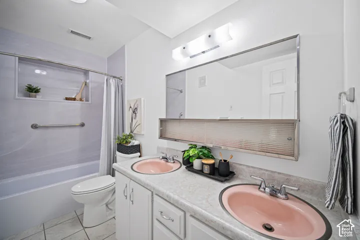 Bathroom featuring a dual vanity with undermount sinks, a built-in shower niche, and a combination tub/shower