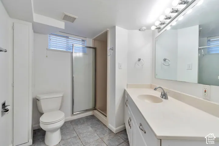 White vanity with integrated sink, chrome faucet, and overhead lighting