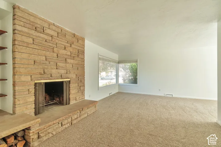 Stone veneer fireplace with hearth and built-in wood storage