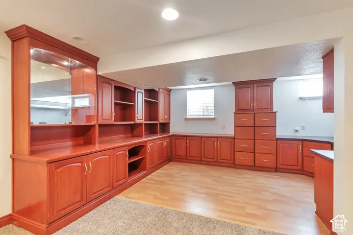 Built-in cherry wood cabinetry with glass-front display cases and open shelving