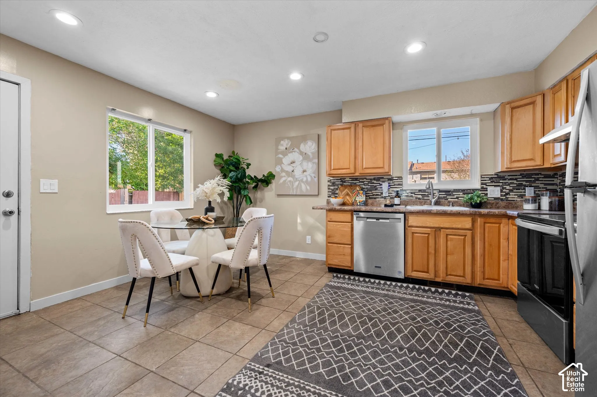 Recessed lighting illuminates the kitchen and dining area with wood-finish cabinetry and stainless steel appliances