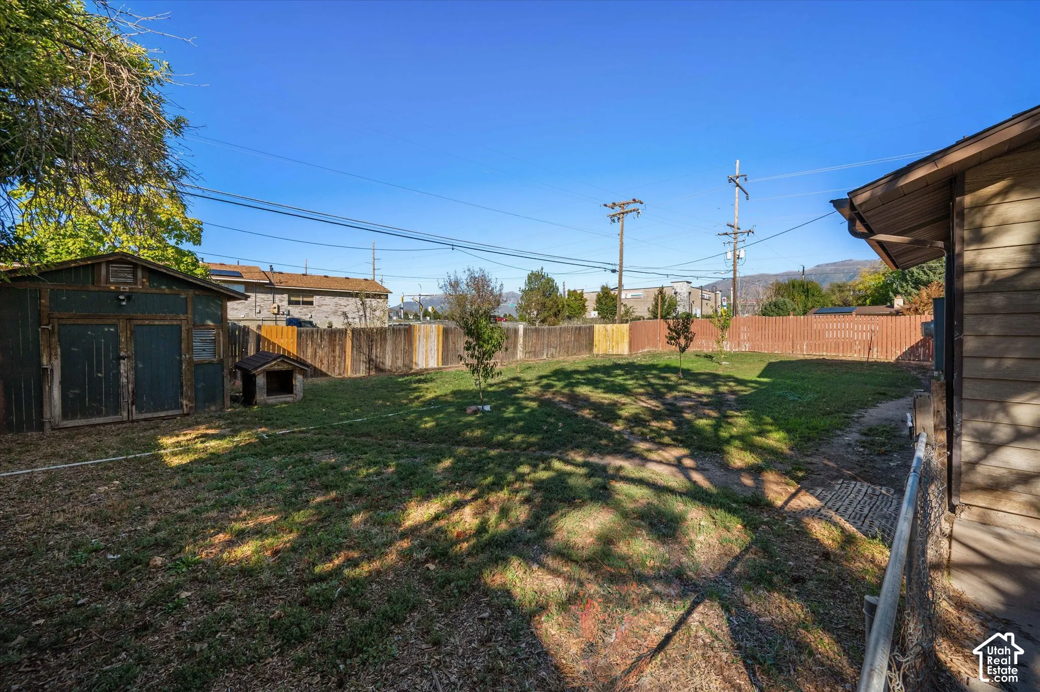 Expansive backyard with a storage shed, wood fencing, and mature trees
