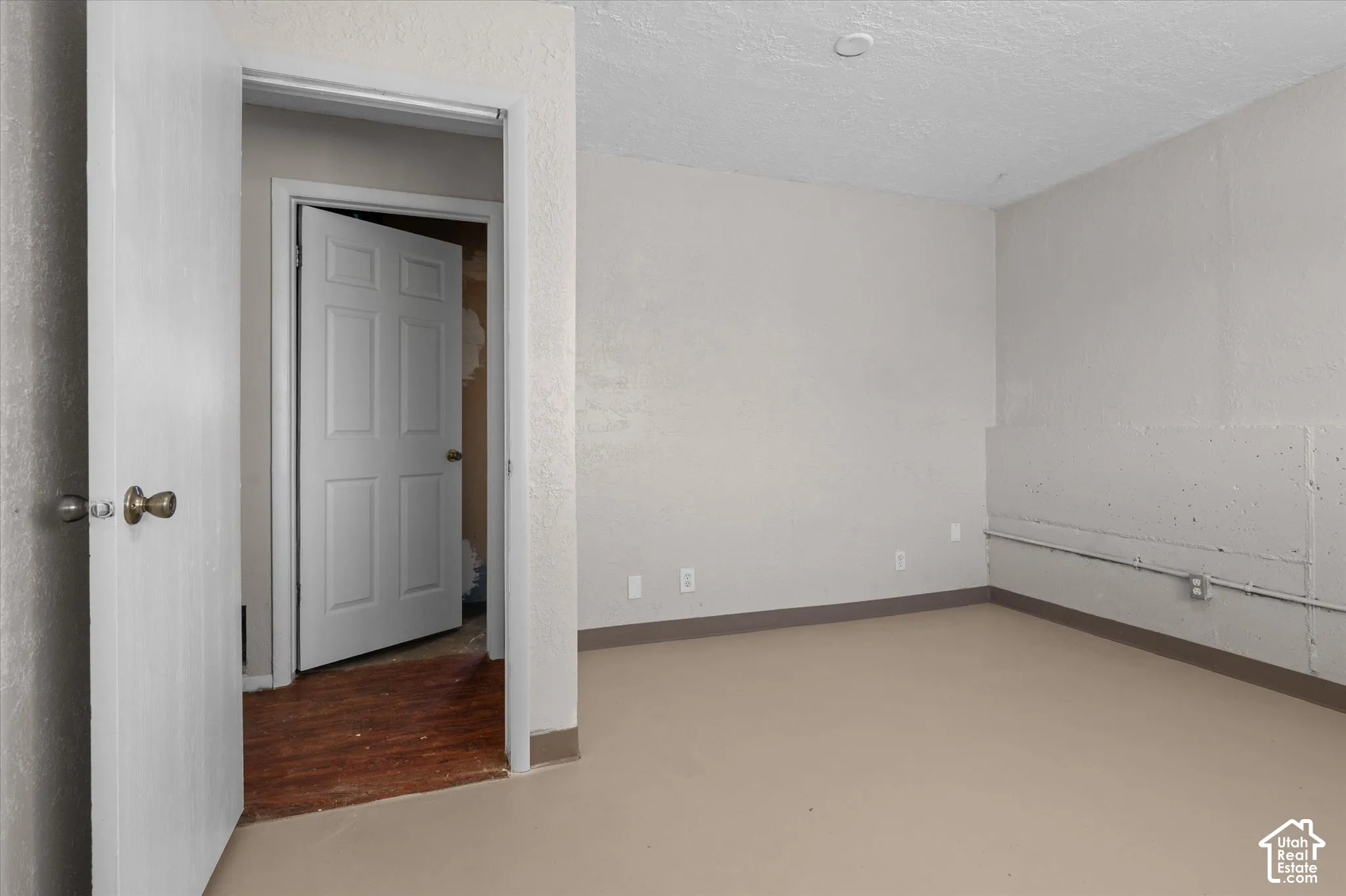 Spacious room featuring neutral wall finishes, wood-finish flooring, and recessed ceiling lighting