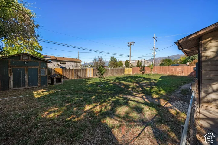 Expansive backyard with a storage shed, wood fencing, and mature trees