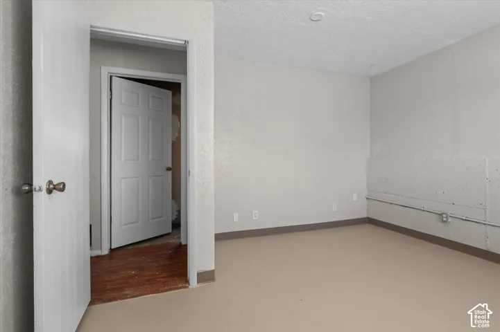 Spacious room featuring neutral wall finishes, wood-finish flooring, and recessed ceiling lighting