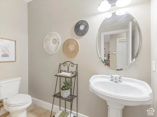 White pedestal sink with chrome faucet and oval mirror