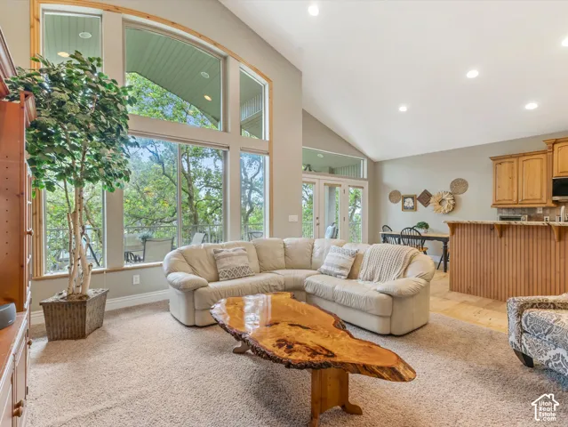 Vaulted ceilings, large picture windows, recessed lighting, wood-finish cabinetry, and French doors