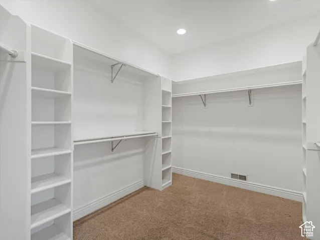 Built-in white shelving with hanging rods and recessed lighting