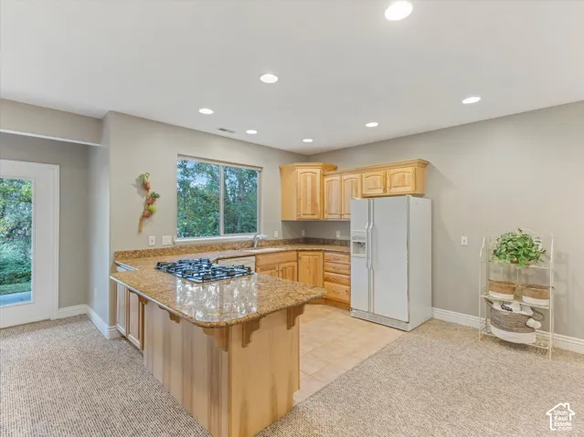 Kitchen featuring wood cabinetry, granite countertops, tile flooring, and recessed lighting