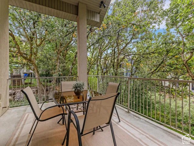 Covered balcony with a textured ceiling, a light-toned concrete floor, and a metal railing