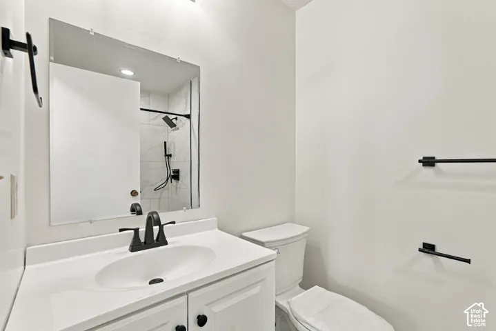 White vanity with integrated sink, matte black faucet, and white countertop