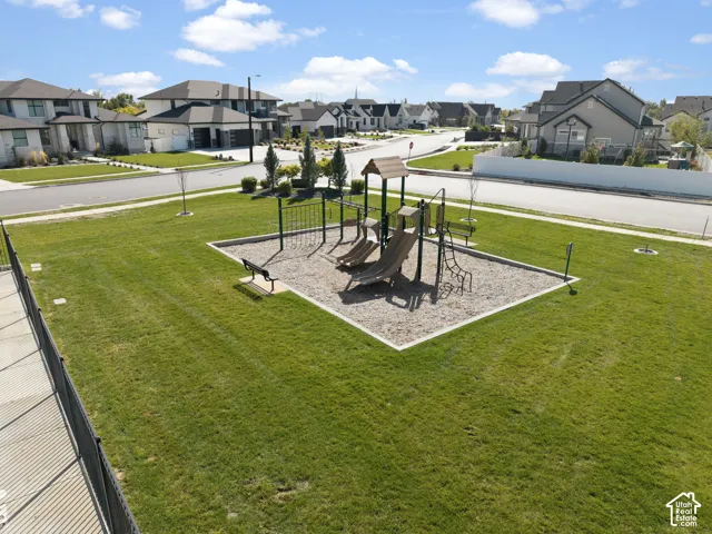 Community green space featuring a playground with slides and a bench