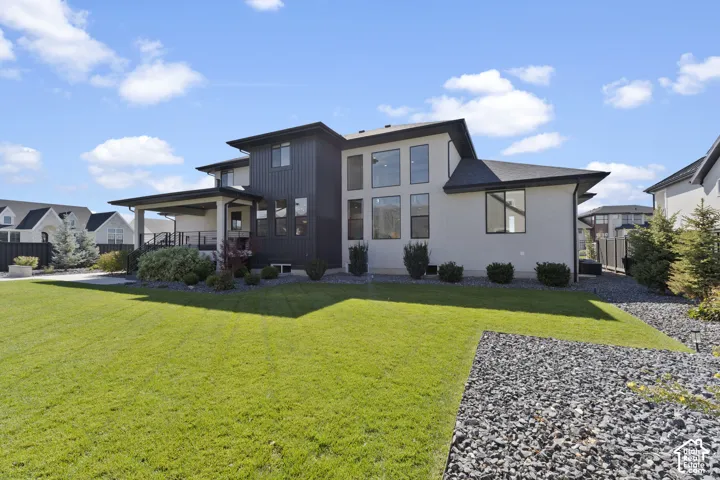 Contemporary exterior with multiple large windows, dark paneling, and light-colored stucco
