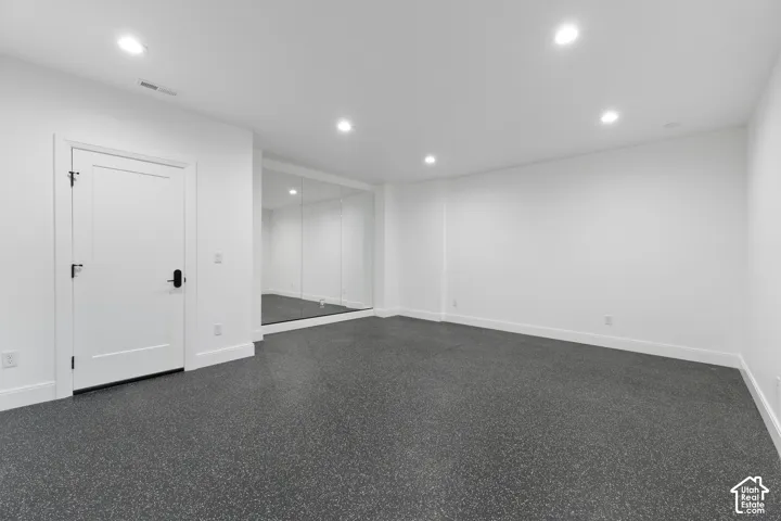 Recessed lighting illuminates the spacious room with durable, speckled flooring