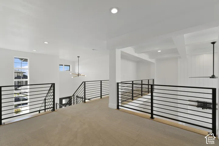 Expansive loft featuring carpet flooring, recessed lighting, and modern black horizontal railing