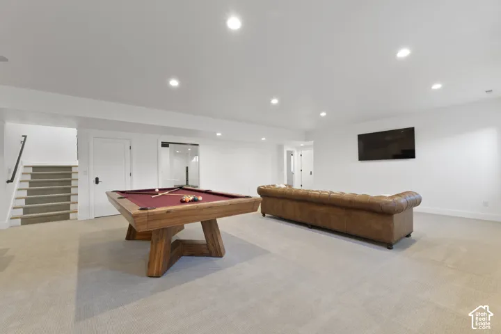 Carpeted flooring, recessed lighting, white walls, built-in wall-mounted television, and a sliding glass door