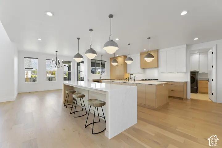 Open-concept kitchen featuring two islands with stone countertops, integrated appliances, and wood-finish flooring