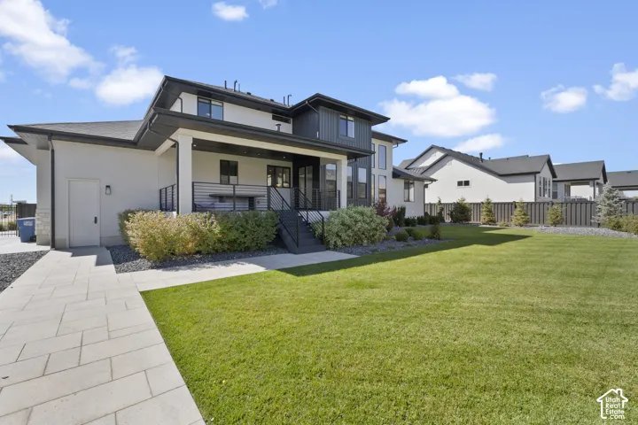 Contemporary exterior with a covered porch, contrasting siding, and a paved walkway